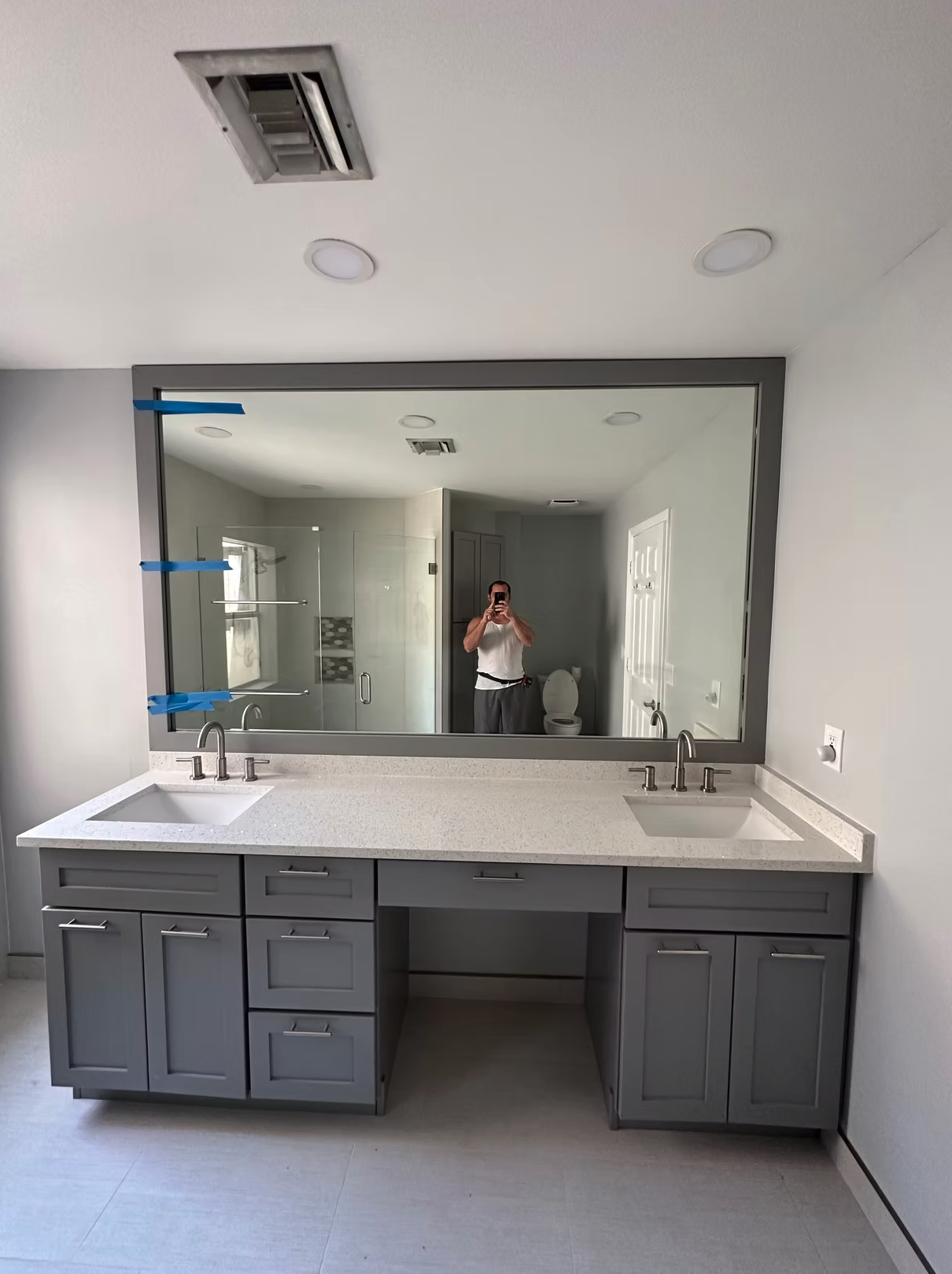Modern bathroom vanity with double sinks and large gray-framed mirror