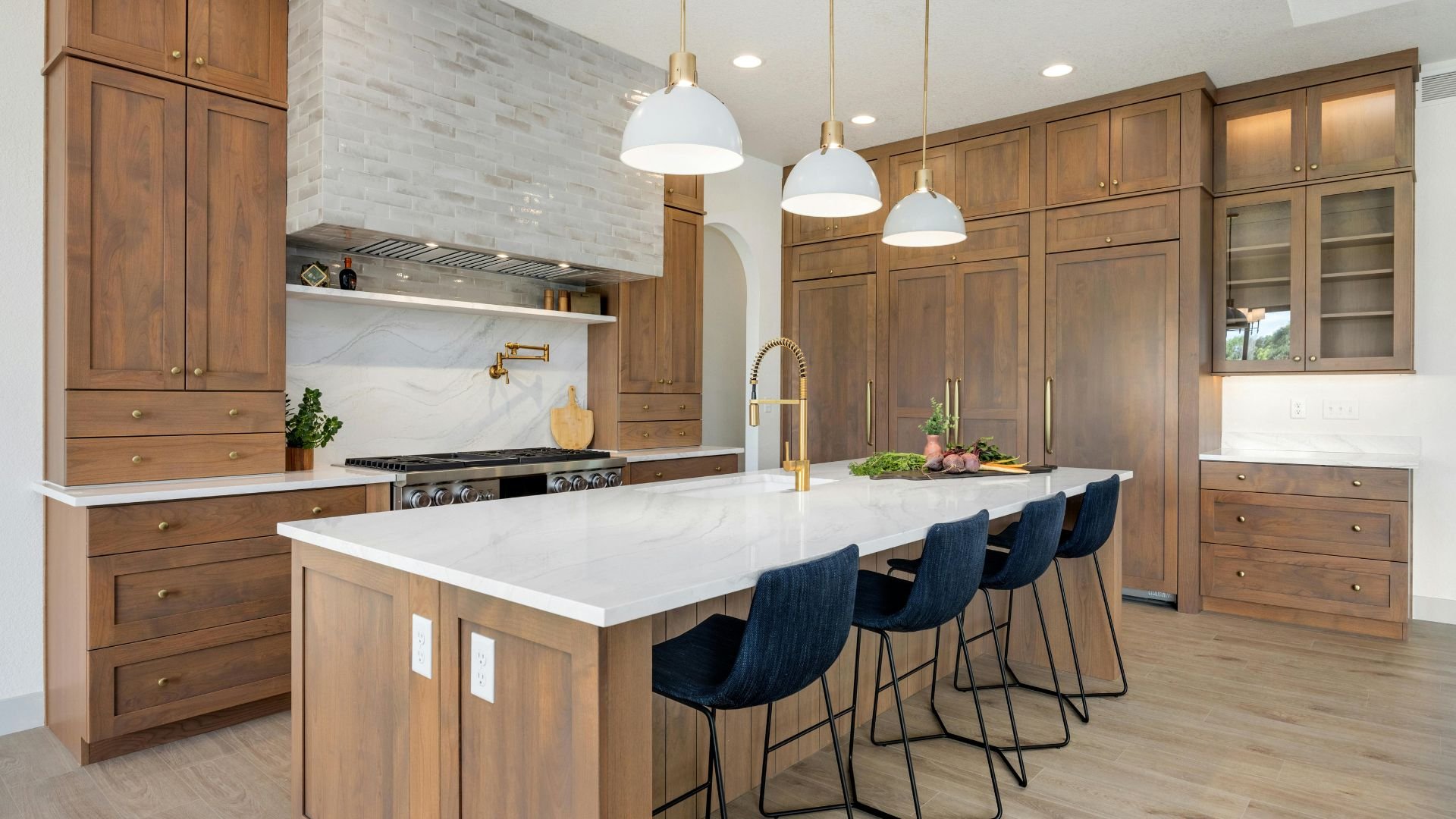 Modern kitchen with wooden cabinets, white countertop, and blue bar stools