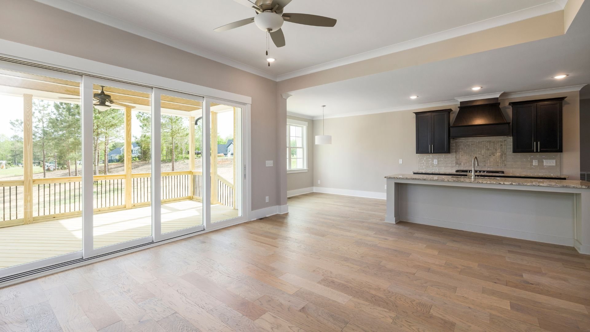 Empty modern open-concept kitchen and living room with wooden deck